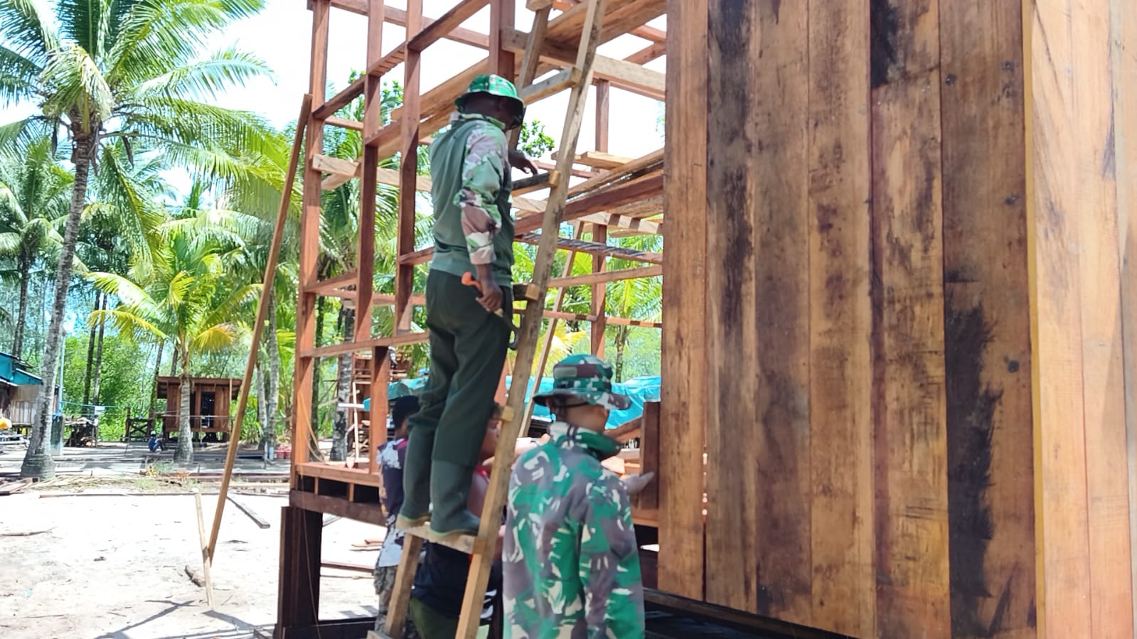 Satgas TMMD dan Warga Kebut Pemasangan Dinding Rumah Niko Makare